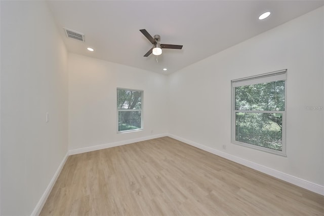 empty room featuring light wood-style flooring, recessed lighting, a ceiling fan, visible vents, and baseboards