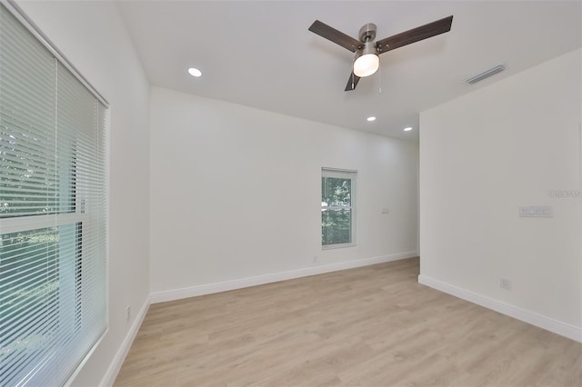 unfurnished room with light wood-style flooring, visible vents, and baseboards