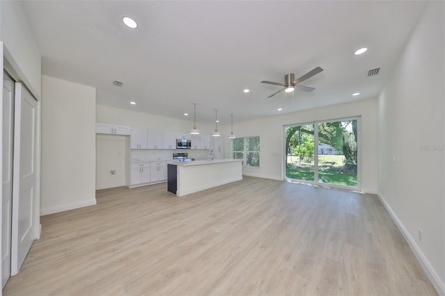 unfurnished living room with light wood-type flooring, visible vents, baseboards, and recessed lighting