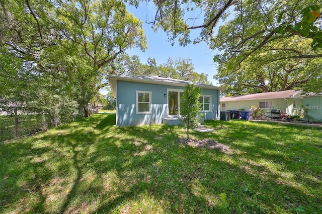 back of house with a yard, central AC unit, and fence