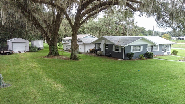 ranch-style house with a garage, a shed, a front lawn, and an outbuilding