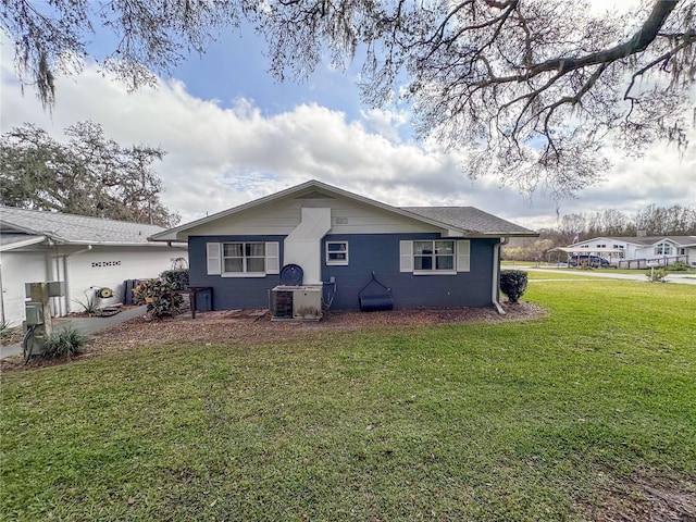 back of house with a yard and central AC unit