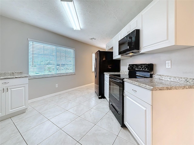 kitchen featuring light tile patterned floors, black appliances, a textured ceiling, and white cabinetry