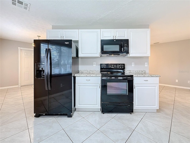 kitchen with black appliances, visible vents, white cabinetry, and light tile patterned flooring