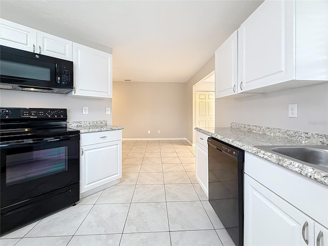 kitchen with black appliances, white cabinets, and light tile patterned flooring