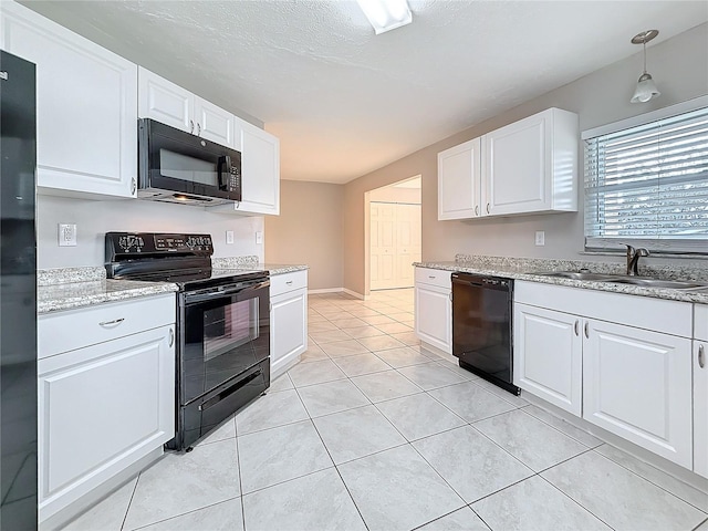 kitchen featuring light tile patterned floors, hanging light fixtures, black appliances, white cabinetry, and a sink