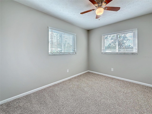 unfurnished room with carpet, a textured ceiling, and baseboards