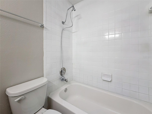 full bath with a textured wall, shower / bathing tub combination, and toilet