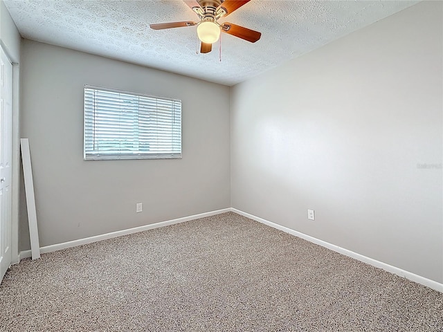 empty room featuring a ceiling fan, carpet, a textured ceiling, and baseboards