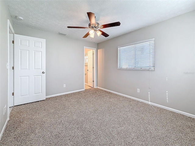 unfurnished bedroom featuring carpet floors, visible vents, ceiling fan, a textured ceiling, and baseboards