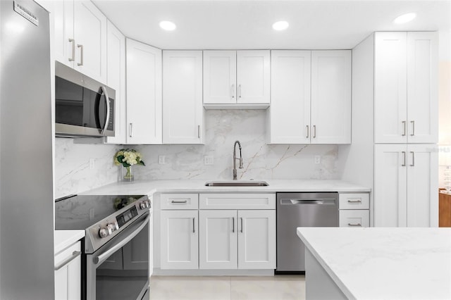 kitchen with appliances with stainless steel finishes, white cabinetry, and a sink