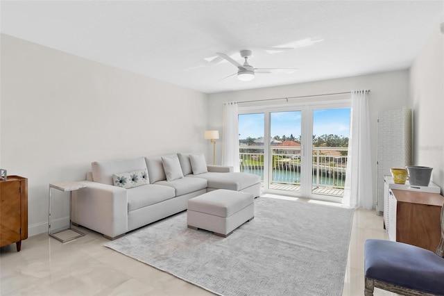 living room featuring a water view, ceiling fan, and baseboards