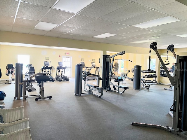 gym with a drop ceiling and a wealth of natural light