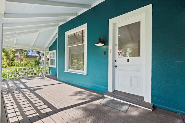 property entrance featuring a porch and stucco siding