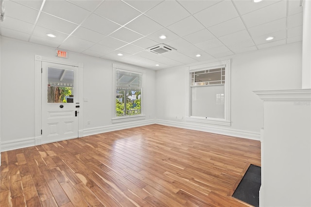 unfurnished room with baseboards, visible vents, and wood finished floors