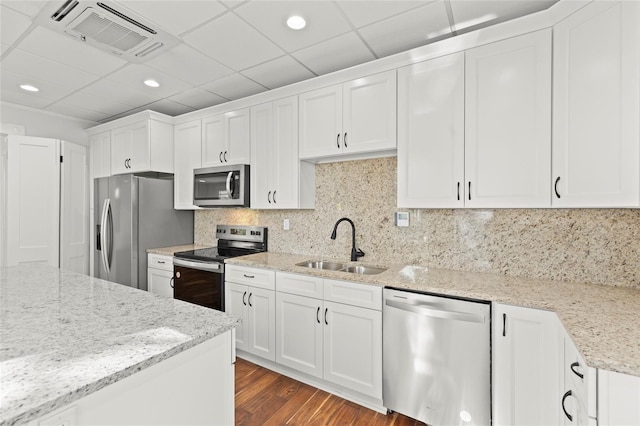 kitchen featuring visible vents, white cabinets, light stone countertops, stainless steel appliances, and a sink