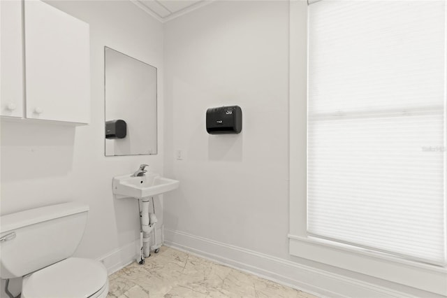 bathroom featuring marble finish floor, a sink, toilet, and baseboards