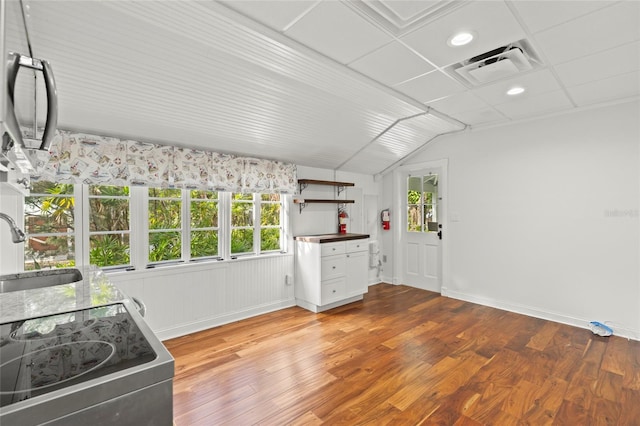 kitchen featuring open shelves, visible vents, electric range, a sink, and wood finished floors