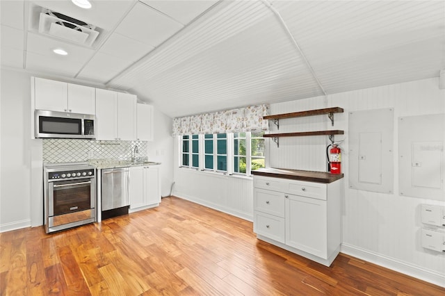 kitchen with open shelves, light wood-style flooring, appliances with stainless steel finishes, white cabinets, and electric panel