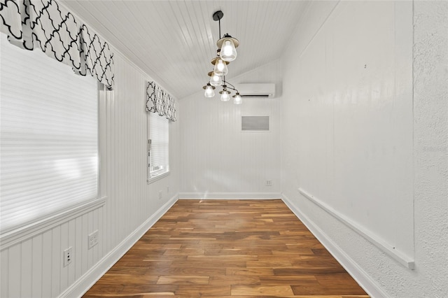 unfurnished dining area with a wall unit AC, vaulted ceiling, and dark wood finished floors