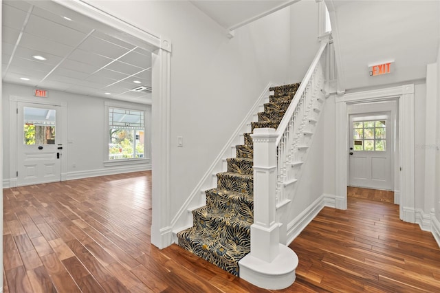 entrance foyer with a paneled ceiling, stairway, baseboards, and dark wood-type flooring