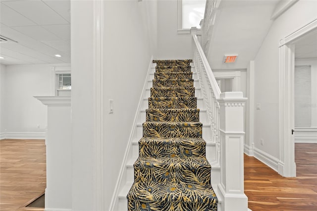 stairs with wood finished floors and baseboards