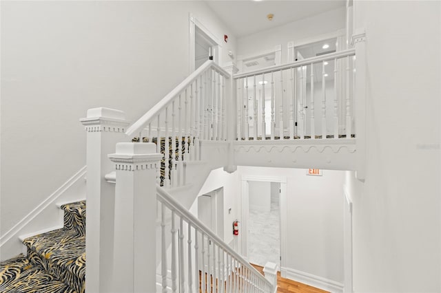 staircase featuring baseboards and wood finished floors