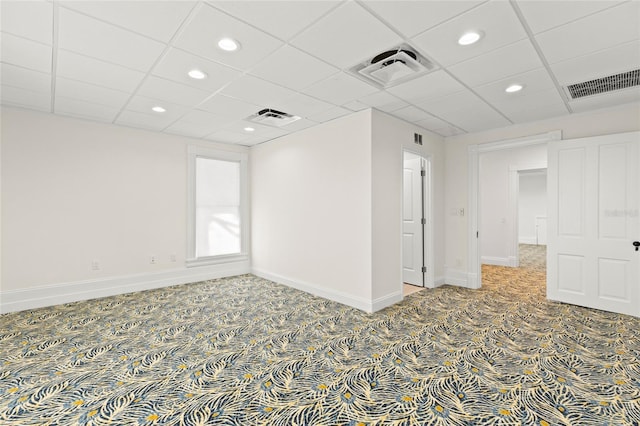 empty room with carpet, visible vents, and baseboards