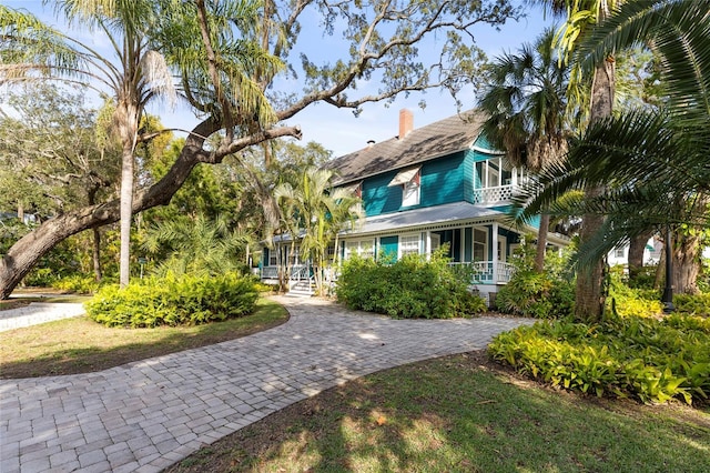 view of front facade featuring a chimney and a front lawn