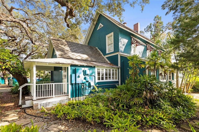 view of front of house featuring a porch and a chimney