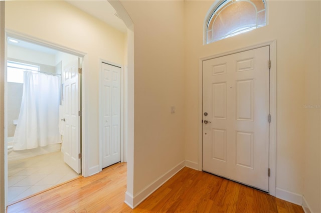 foyer entrance featuring light wood-style floors and baseboards