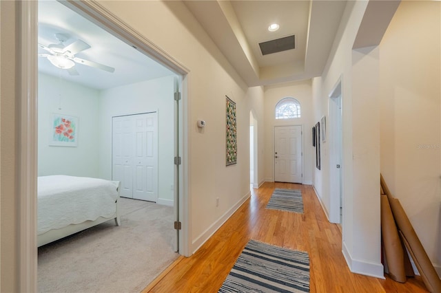 doorway with light wood-style flooring, visible vents, and baseboards