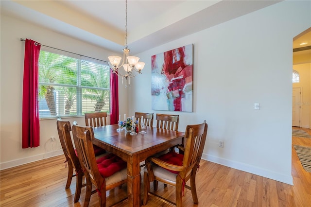 dining area with light wood-style floors, baseboards, and a notable chandelier