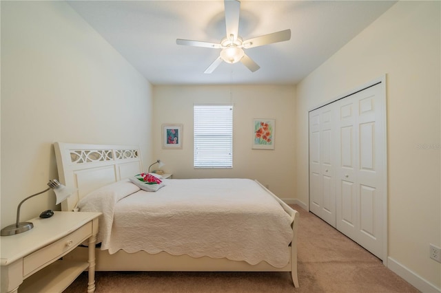 bedroom featuring a closet, light colored carpet, ceiling fan, and baseboards