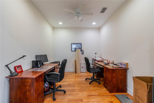 home office featuring light wood-type flooring, baseboards, visible vents, and a ceiling fan