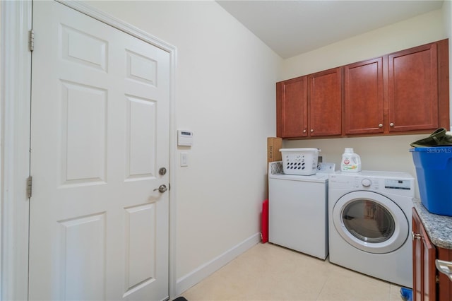 washroom featuring light tile patterned floors, independent washer and dryer, cabinet space, and baseboards