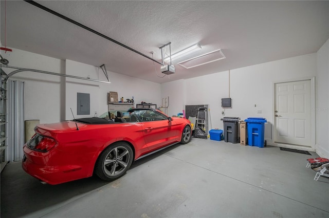 garage with a garage door opener and electric panel