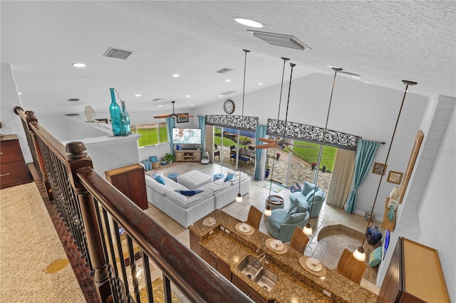 living area with visible vents, a textured ceiling, and a healthy amount of sunlight