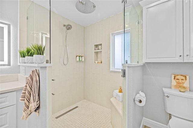 full bathroom featuring tiled shower, toilet, and vanity