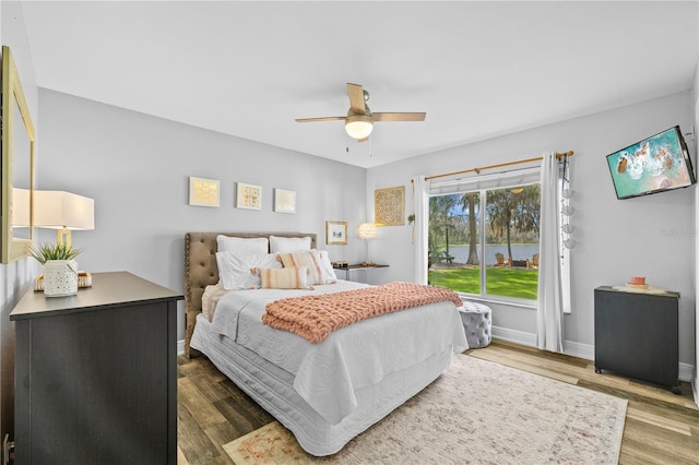 bedroom featuring a ceiling fan, baseboards, and wood finished floors