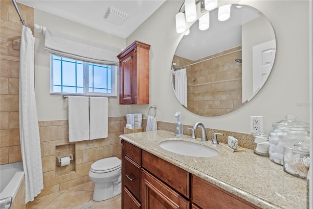 full bathroom featuring a wainscoted wall, visible vents, tile walls, toilet, and tile patterned floors