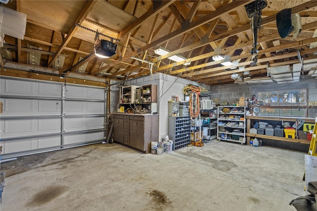 garage featuring concrete block wall and a garage door opener