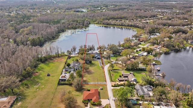 drone / aerial view featuring a forest view, a water view, and a residential view