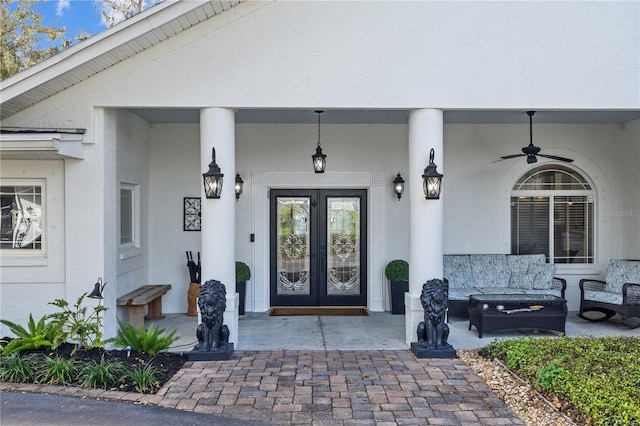 property entrance with stucco siding, french doors, outdoor lounge area, and ceiling fan