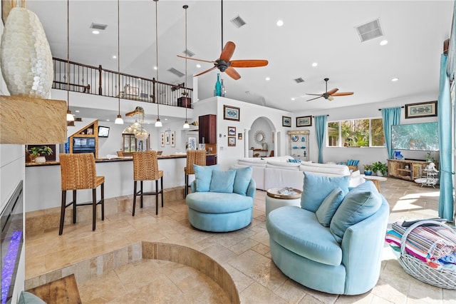 living room with arched walkways, visible vents, and recessed lighting