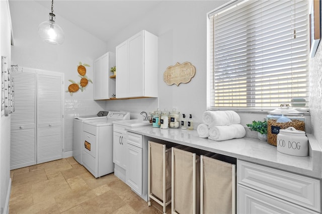 laundry area with cabinet space, independent washer and dryer, and stone finish floor