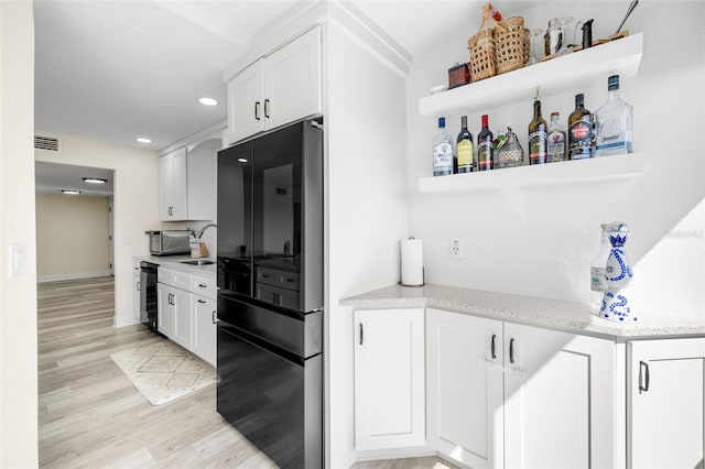 kitchen featuring visible vents, white cabinetry, open shelves, and freestanding refrigerator