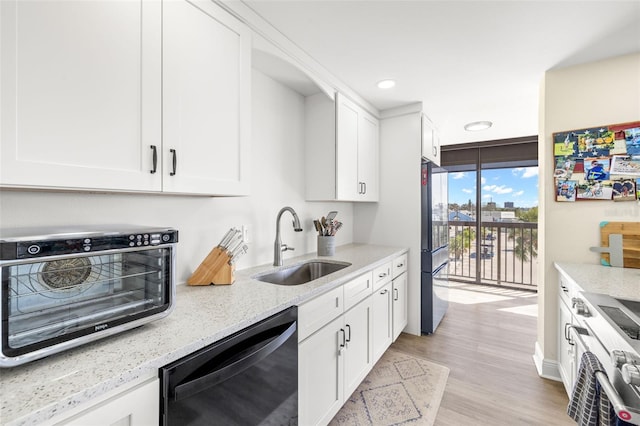 kitchen featuring light stone counters, stainless steel appliances, white cabinetry, floor to ceiling windows, and a sink