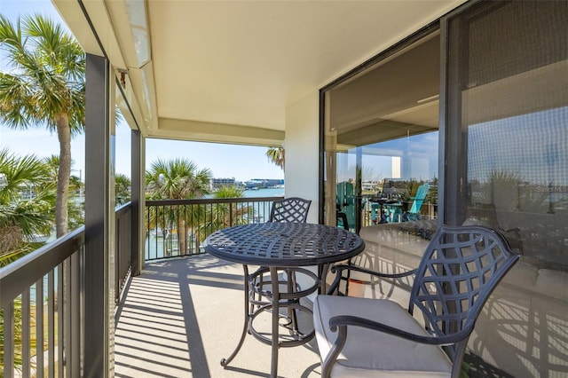 balcony featuring a sunroom and a water view