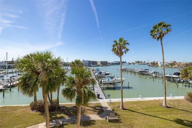 view of dock featuring a water view, boat lift, and a lawn